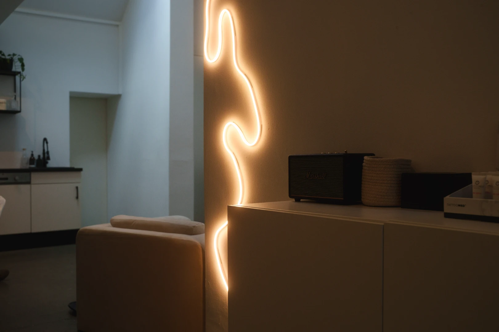 Bouclé-Sessel und Lichtinstallation im Loft des The Bare Skin Lab